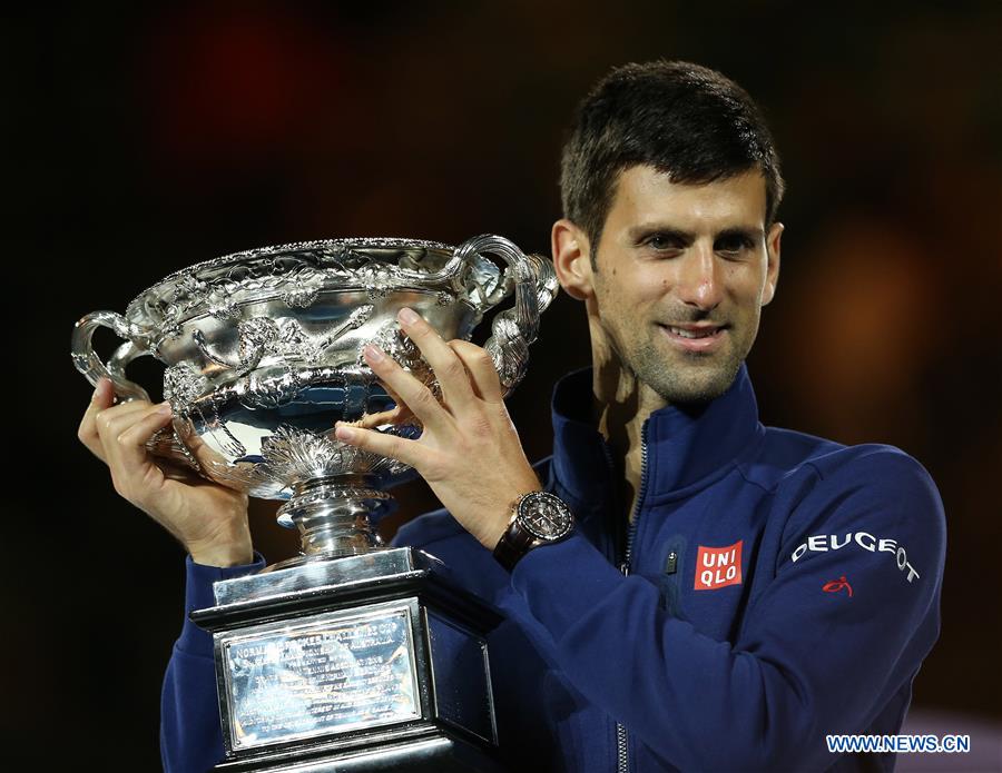 Novak Djokovic of Serbia poses with the trophy after winning the final of men's singles against Andy Murray of Great Britain at the Australian Open Tennis Championships in Melbourne, Australia, Jan. 31, 2016. Novak Djokovic won the match 6-1, 7-5, 7-6.