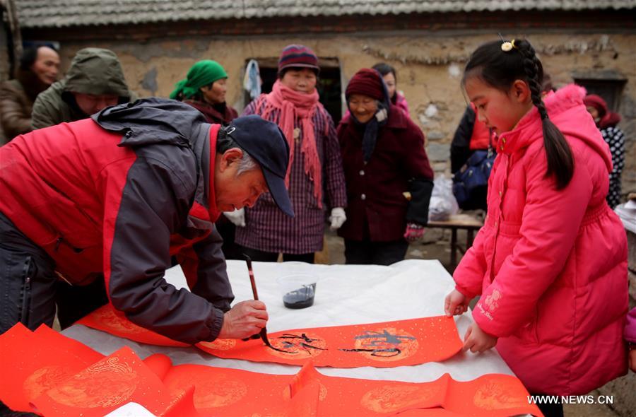 A villager writes couplets to greet the Spring Festival in Tushan Village of Xuzhou, east China's Jiangsu Province, Jan. 31, 2016