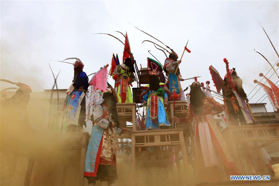 People perform Gaotai Dixi, a local folk opera staged on the open space of flat land, at Weiqi Village of Puding County, southwest China's Guizhou Province, Feb. 15, 2016. 