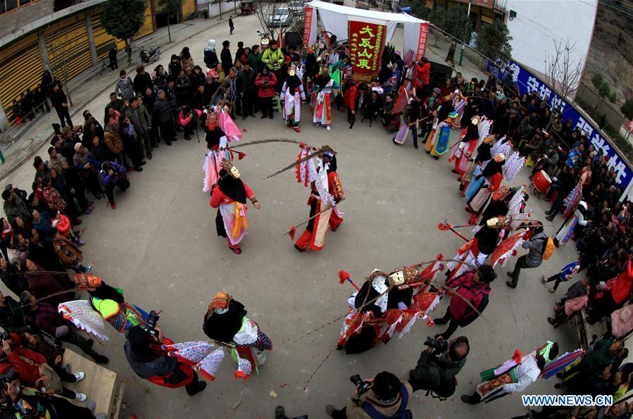 People perform Gaotai Dixi, a local folk opera staged on the open space of flat land, at Weiqi Village of Puding County, southwest China's Guizhou Province, Feb. 15, 2016.