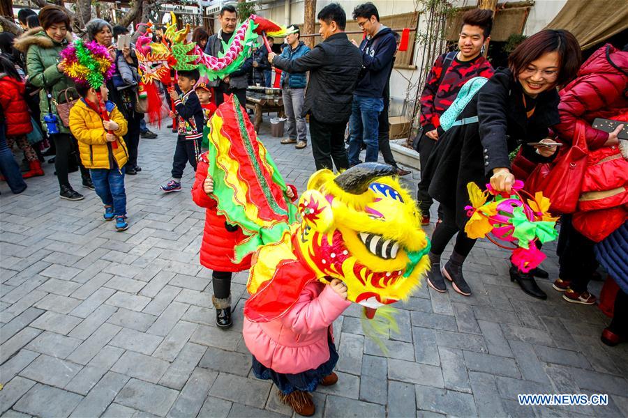 Children experience dragon dance at Ziyuan Art Park in Tianjin, north China, Feb. 21, 2016. 