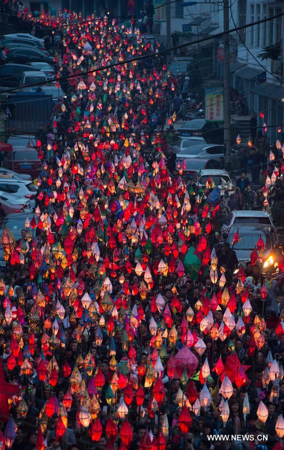 Local residents hold a lantern parade to celebrate the Toad Festival, a tradition to wish for good health and harvest in the lunar new year when people send away a symbolic toad figure representing illness, in Nanchong, southwest China's Sichuan Province, Feb. 21, 2016.