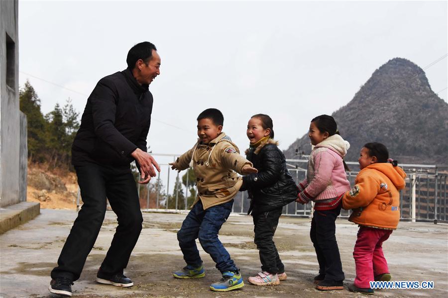 Primary school teacher Tao Chaolei, 52, plays games with his four students, including one in grade three and three pre-school kids, at the start of the new term at Sujiacun Village of Wushan County in southwest China's Chongqing, Feb. 24, 2016. 