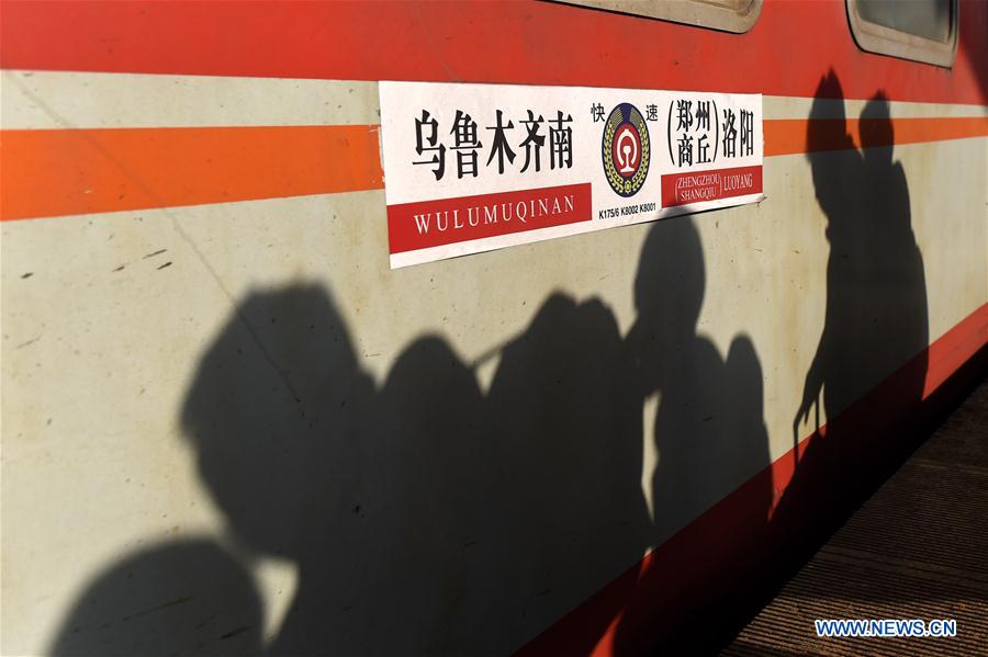 Passengers' shadows are seen on a train at the railway station of Zhengzhou, capital of central China's Henan Province, Feb. 24, 2016.