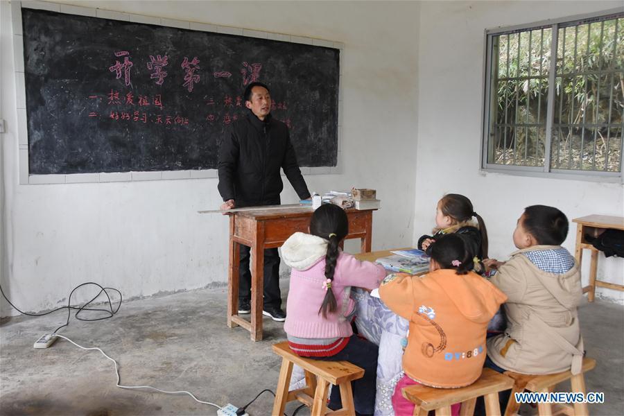 Primary school teacher Tao Chaolei, 52, starts the first lesson of new term for four students, including one in grade three and three pre-school kids, at the start of the new term at Sujiacun Village of Wushan County in southwest China's Chongqing, Feb. 24, 2016.