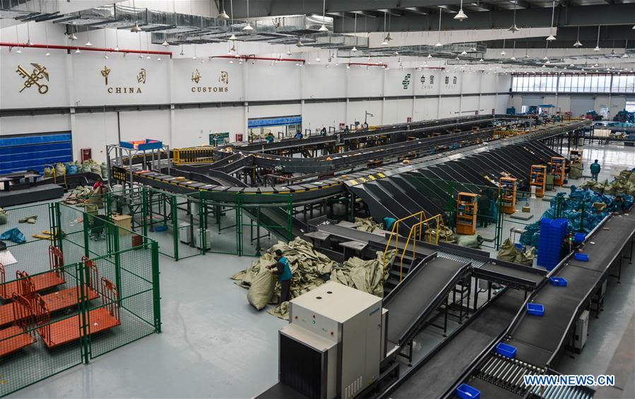 Staff members sort out outbound packages and mails at Yiwu International Mail Station in Yiwu, east China's Zhejiang Province, Feb. 25, 2016.