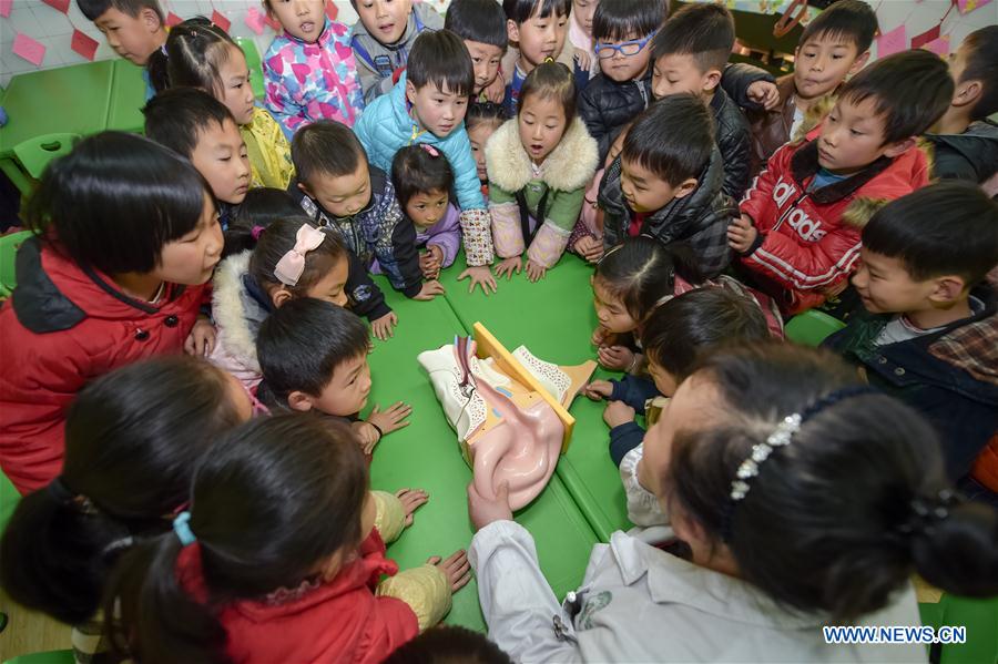 Young kids at Tuan'anxincun kindergarten learn about human's ear structure in Hefei, capital of east China's Anhui Province, March 1, 2016, two days ahead of China's national ear-care day. 