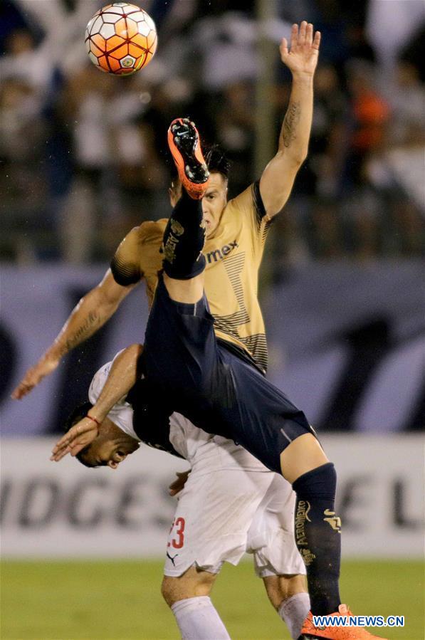 Image taken for Club Universidad Nacional A.C. (PUMAS) shows Olimpia's Julian Benitez (Back) of Paraguay vying for the ball with UNAM's Pumas Marcelo Alatorre of Mexico during the match of Group 7 of Copa Libertadores, at Manuel Ferreira Stadium in Asuncion, capital of Paraguay, on March 1, 2016.