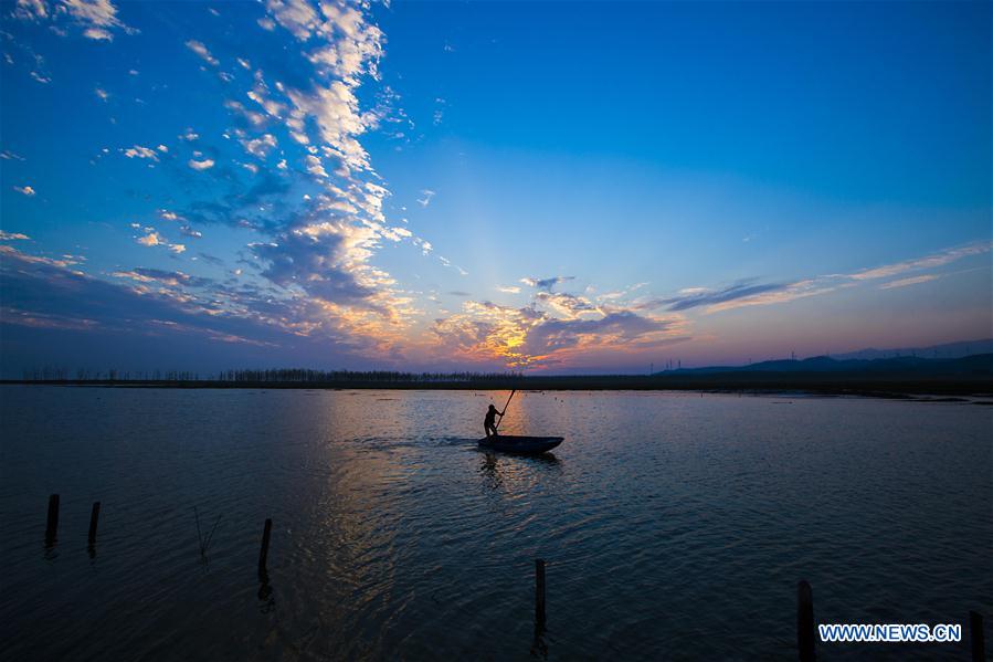 Fishing boats sail on the Poyang Lake in Duchang County, east China's Jiangxi Province, Sept. 20, 2014. 