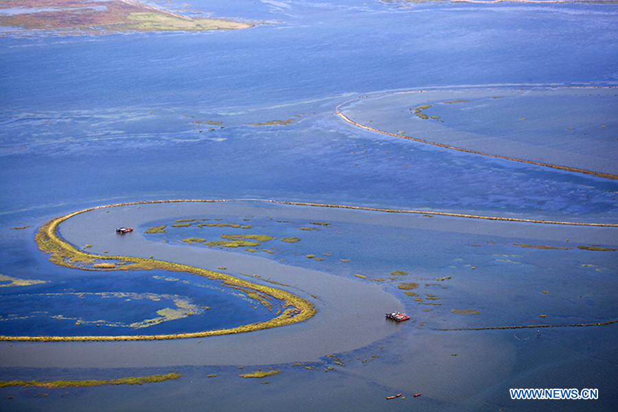 Fishing boats sail on the Poyang Lake in Duchang County, east China's Jiangxi Province, Sept. 20, 2014. 