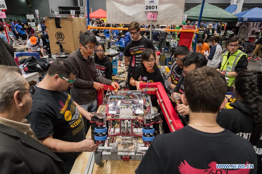 Team members of 'FLYBOTS' from Brooklyn's Paul Robeson High School work on their robot at the 2016 FIRST Robotics Competition New York Regional in Jacob Javits Convention Center in New York City, the United States, March 11, 2016.