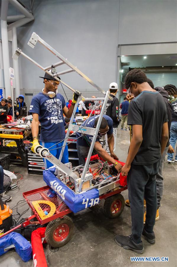 Team members of 'FLYBOTS' from Brooklyn's Paul Robeson High School work on their robot at the 2016 FIRST Robotics Competition New York Regional in Jacob Javits Convention Center in New York City, the United States, March 11, 2016.