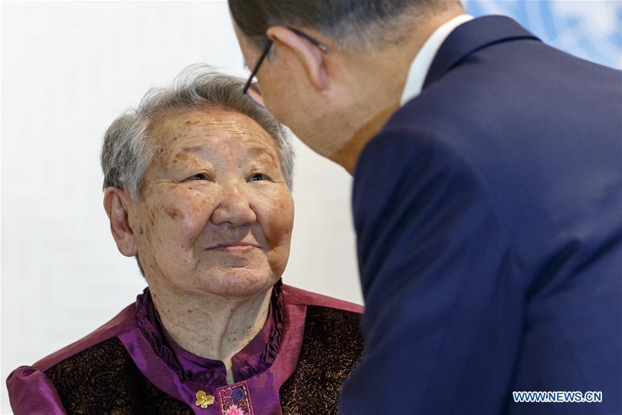 United Nations Secretary-General Ban Ki-moon (R) and his wife Yoo Soon-taek (L) pose for a photo with Gil Won-ok, one of the victims who were drafted by Japan as so-called 'comfort women' during the Second World War, at the UN headquarters in New York, March 11, 2016.