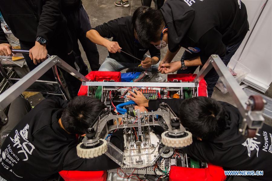 Team members of 'FLYBOTS' from Brooklyn's Paul Robeson High School work on their robot at the 2016 FIRST Robotics Competition New York Regional in Jacob Javits Convention Center in New York City, the United States, March 11, 2016.