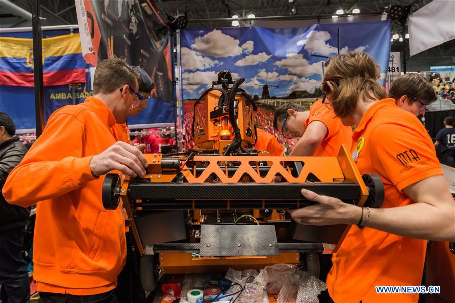 Team members of 'FLYBOTS' from Brooklyn's Paul Robeson High School work on their robot at the 2016 FIRST Robotics Competition New York Regional in Jacob Javits Convention Center in New York City, the United States, March 11, 2016.