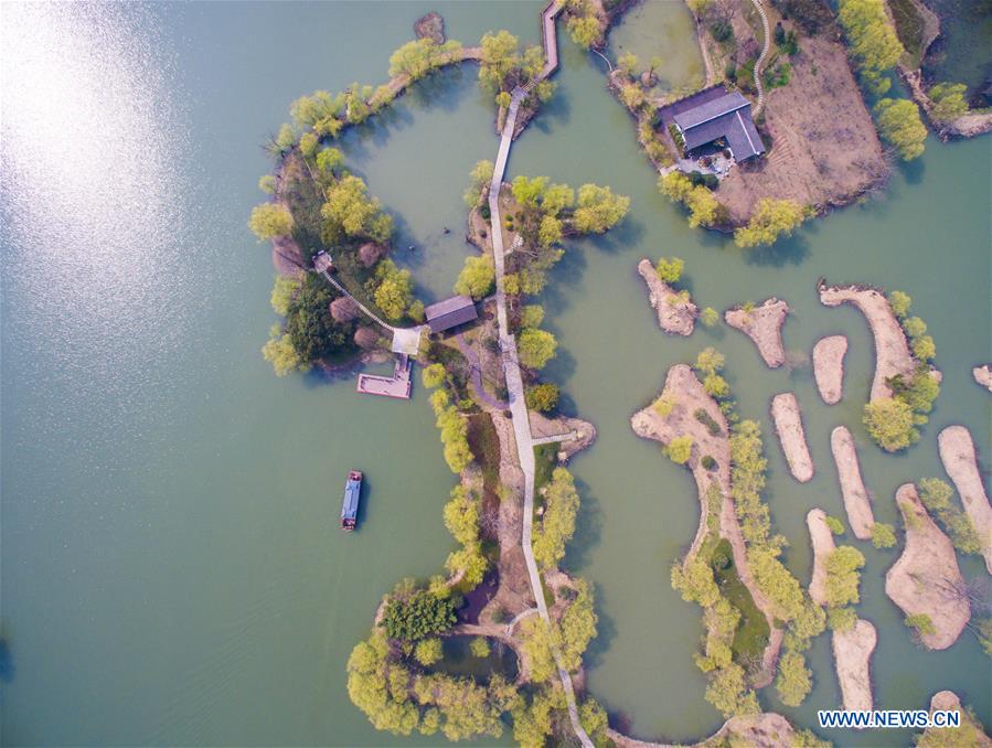 A sightseeing boat sails on water at a wetland by the Taihu Lake in Changxing County, est China's Zhejiang Province, March 16, 2016. 