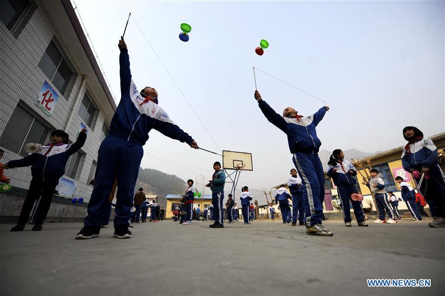 Pupils of Kuaihuolin Primary School exercise with diabolos in Xinglong County of Chengde City, north China's Hebei Province, March 16, 2016.