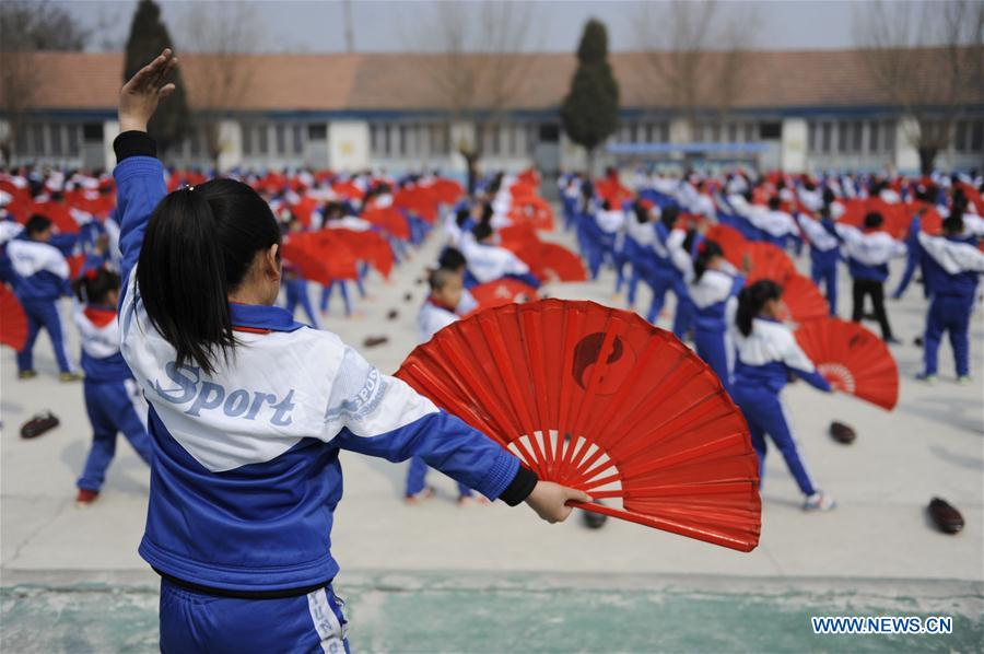 Pupils of Foyelai Primary School exercise with Taiji fans in Xinglong County of Chengde City, north China's Hebei Province, March 16, 2016. 