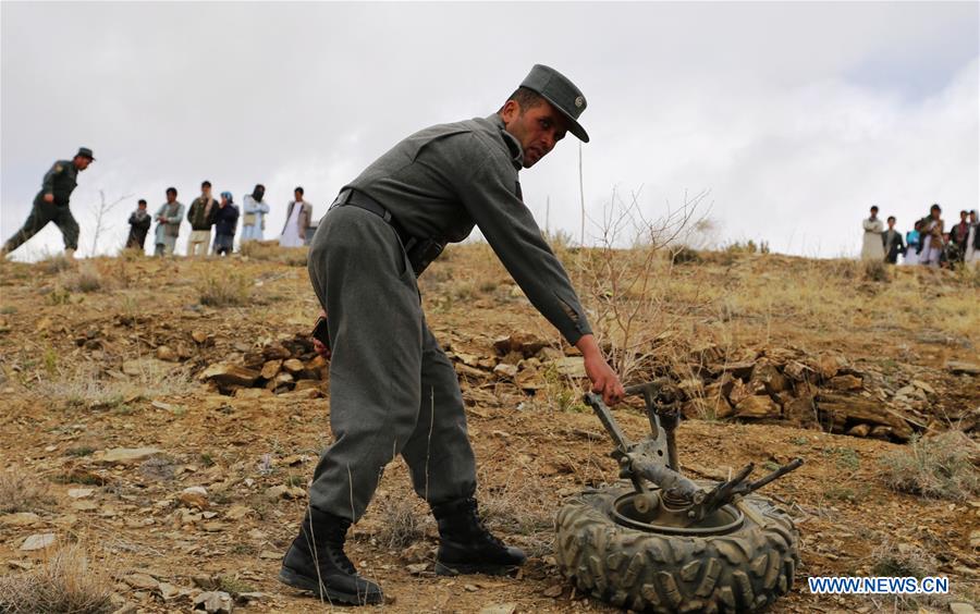 Afghan policemen inspect the site of a blast in Ghazni province, east Afghanistan, March 20, 2016.