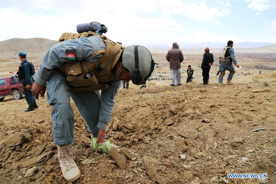 Afghan policemen inspect the site of a blast in Ghazni province, east Afghanistan, March 20, 2016.