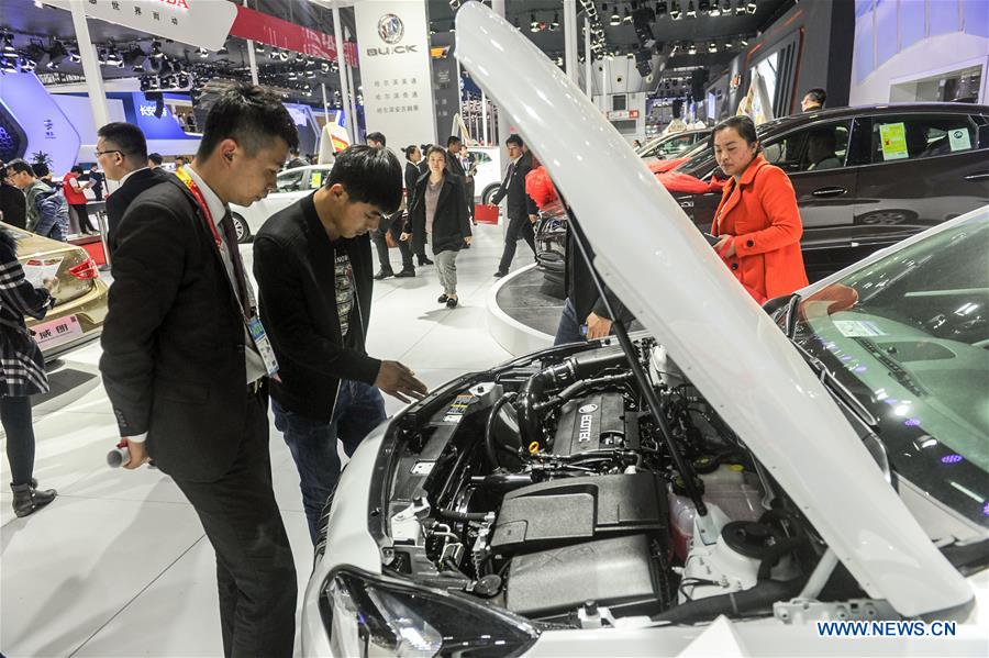 A man views the engine of a Buick auto during the 11th Harbin spring auto show in Harbin, capital of northeast China's Heilongjiang Province, March 22, 2016.