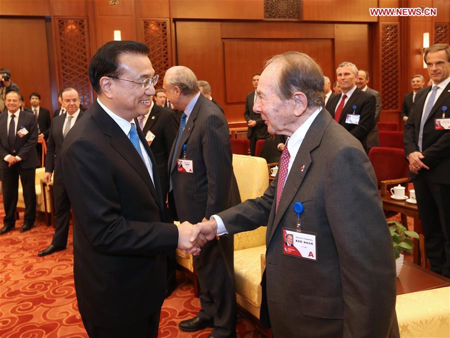 Chinese Premier Li Keqiang (L) shakes hands with Maurice R. Greenberg during a meeting with overseas delegates attending the China Development Forum in Beijing, capital of China, March 21, 2016.