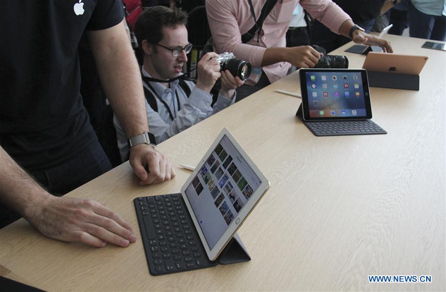 Visitors take photos of the new iPhones, named iPhone SE, during an event to announce new products at Apple's headquarters in Cupertino, California, the United States, March 21, 2016. 