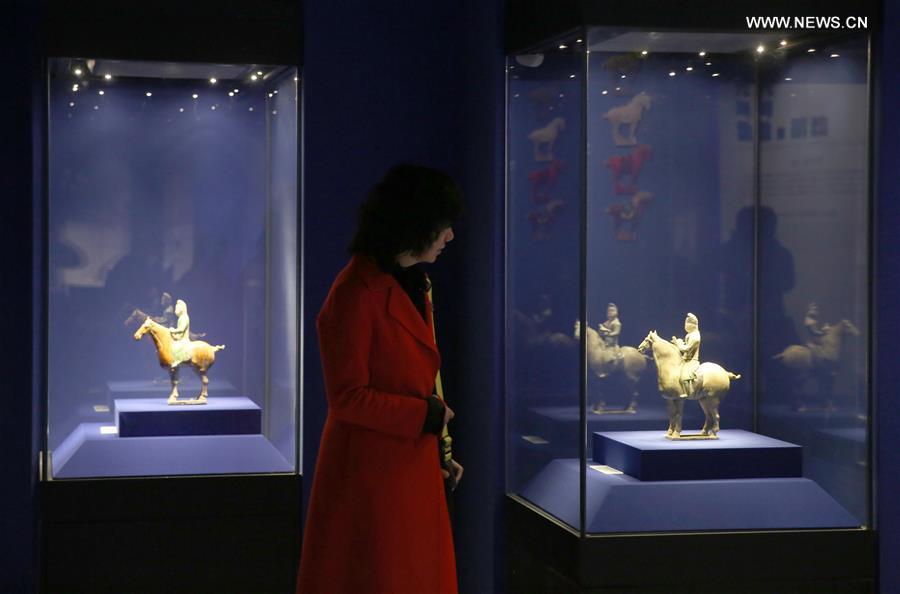 A visitor looks at a tri-colored glazed pottery work is seen displayed at an exhibition in Shaanxi History Museum in Xi'an, capital of northwest China's Shaanxi Province, March 23, 2016. 