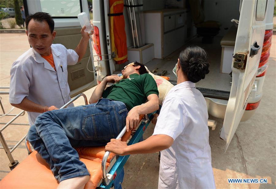 Medical workers transfer a wounded Chinese citizen to an ambulance in Vientiane, Laos, on March 24, 2016. 