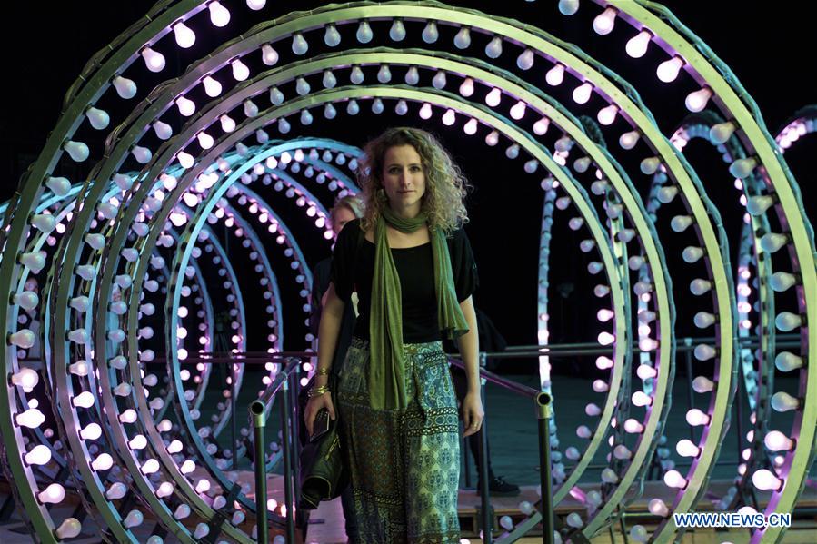 A visitor looks at an artwork 'Double Neon Elevator', part of the exhibition 'Doubt' in Milan, Italy, on April 6, 2016. 