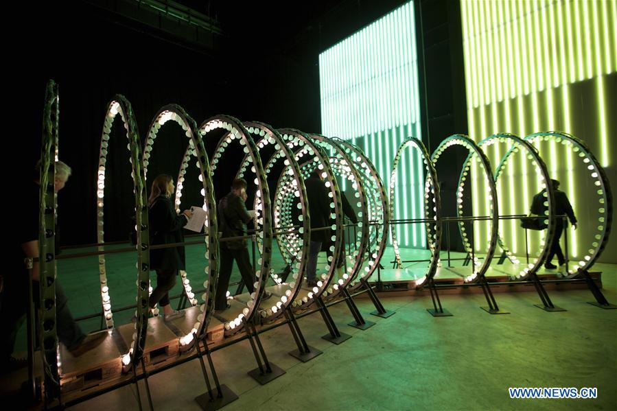 A visitor looks at an artwork 'Double Neon Elevator', part of the exhibition 'Doubt' in Milan, Italy, on April 6, 2016. 