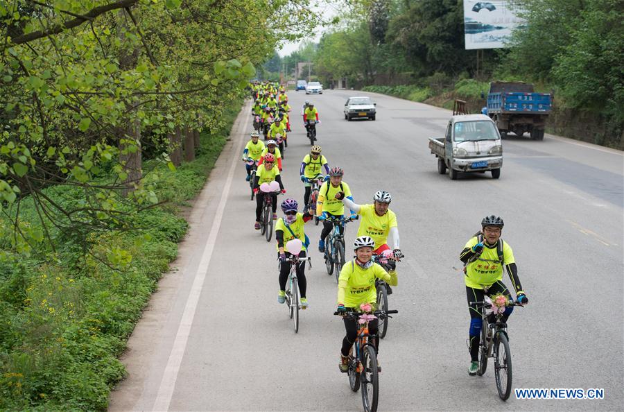 Bridegroom Zeng Di (R, front) and bride Wang Lixia (L, front) ride during their wedding in Chengdu, capital of southwest China's Sichuan Province, April 9, 2016.