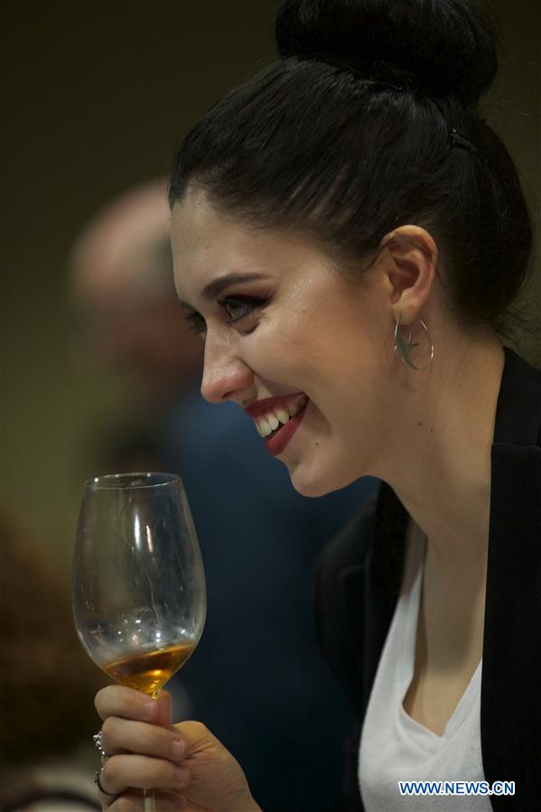 A visitor tastes the wine at Italy's Lombardy hall during Vinitaly in Verona, Italy, on April 11, 2016. Vinitaly 2016, the 50th edition of this international wine fair, began Sunday and will run until Wednesday, April 13. 