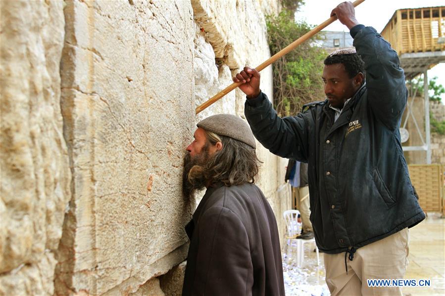 Employees remove thousands of handwritten notes placed between stones of the Western Wall, Judaism's holiest site in the Old City of Jerusalem, on April 12, 2016.