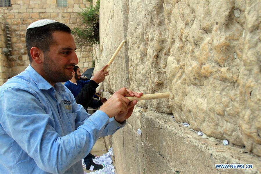 Employees remove thousands of handwritten notes placed between stones of the Western Wall, Judaism's holiest site in the Old City of Jerusalem, on April 12, 2016.