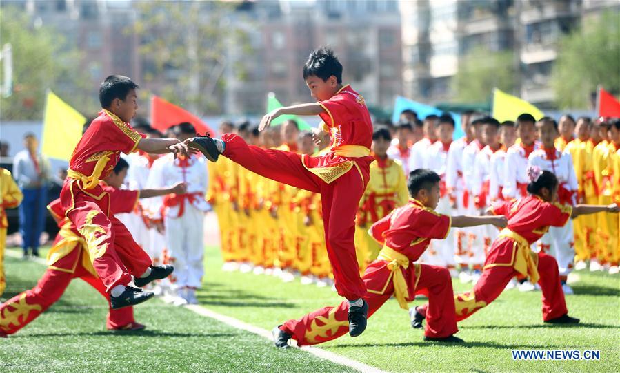 Pupils exercise with Taiji fans at the Yixingbu No. 1 Primary School in Tianjin, north China, April 14, 2016. 