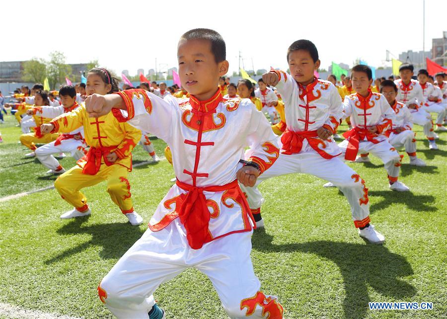 Pupils exercise with Taiji fans at the Yixingbu No. 1 Primary School in Tianjin, north China, April 14, 2016. 