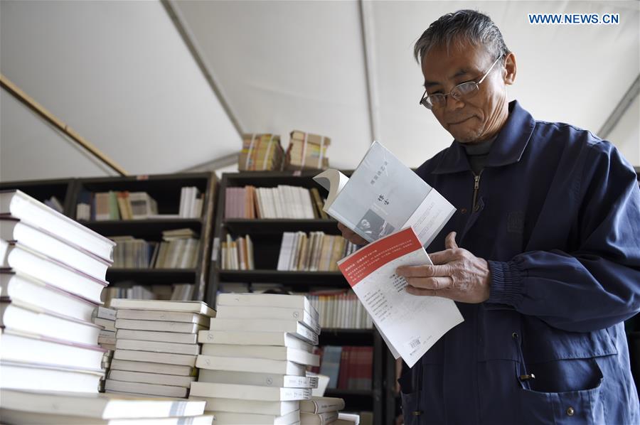 A man selects books at a book fair in Chaoyang Park in Beijing, capital of China, April 15, 2016.