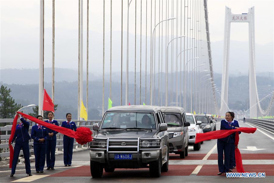 People attend the opening ceremony of Longjiang grand bridge in southwest China's Yunnan Province, April 20, 2016. 