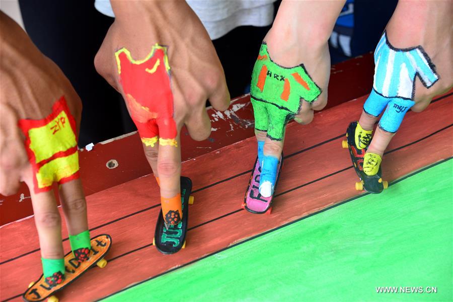 Students take part in a finger skateboard match at the School of Physical Education of the Liaocheng University in Liaocheng City, east China's Shandong Province, April 28, 2016