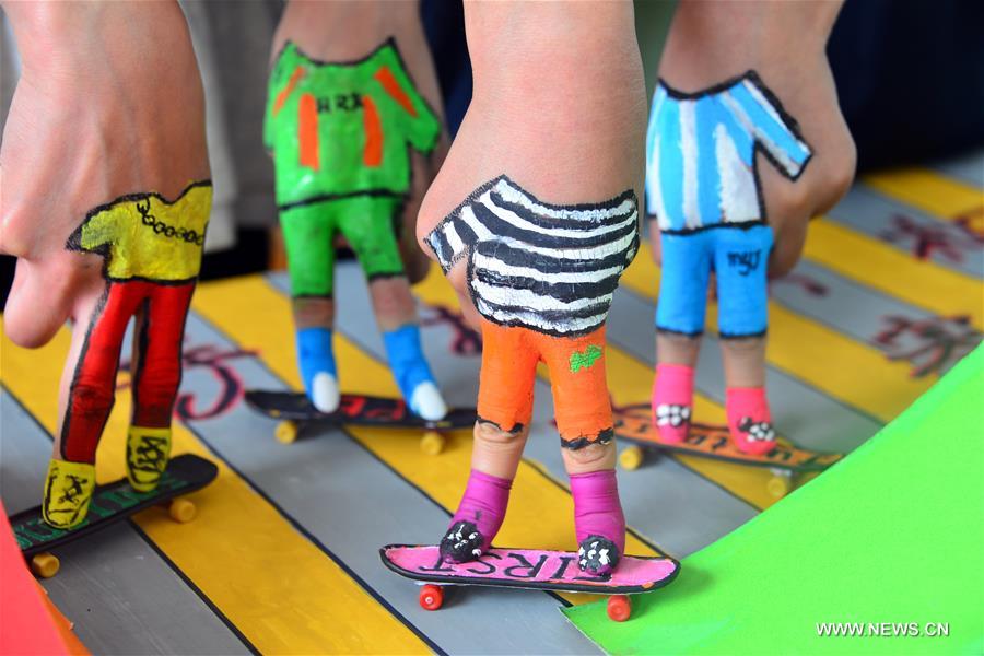 Students take part in a finger skateboard match at the School of Physical Education of the Liaocheng University in Liaocheng City, east China's Shandong Province, April 28, 2016