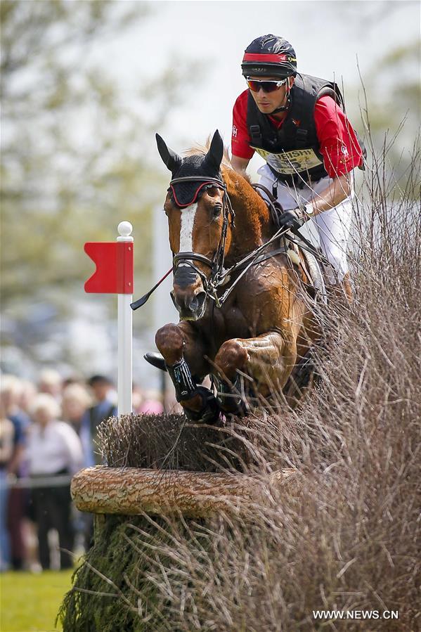 Chinese rider Alex Hua Tian with his horse 'Harbour Pilot C' jumps through the fence in Cross-Country Course at 2016 Badminton Horse Trials in Badminton, England on May 7, 2016.