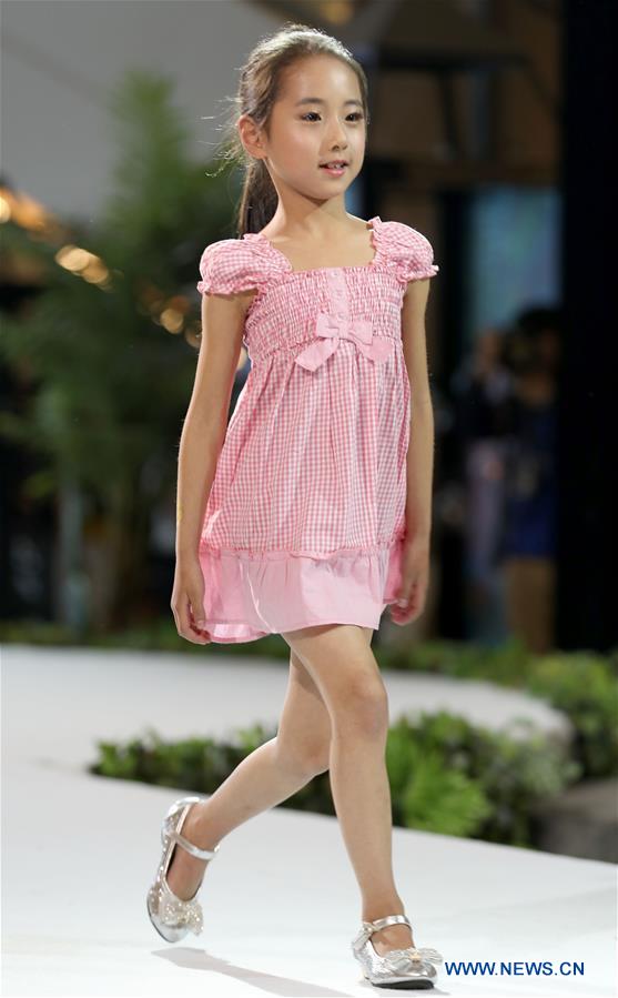 A child model presents a Babby Angie children's garment at 'vogue Zhucheng ' fashion show during the 16th China (Qingdao)International Fashion Week in Qingdao, east China's Shandong Province, May 12, 2016. 