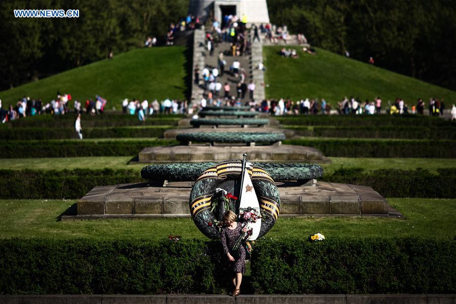 A woman holds flowers as she visits the Soviet Memorial in Treptower Park in Berlin, Germany, on May 9, 2016. 