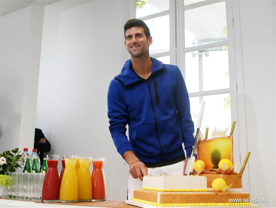 Serbia's Novak Djokovic cuts his birthday cake at the Roland Garros 2016 French Open tennis tournament in Paris, France on May 22, 2016