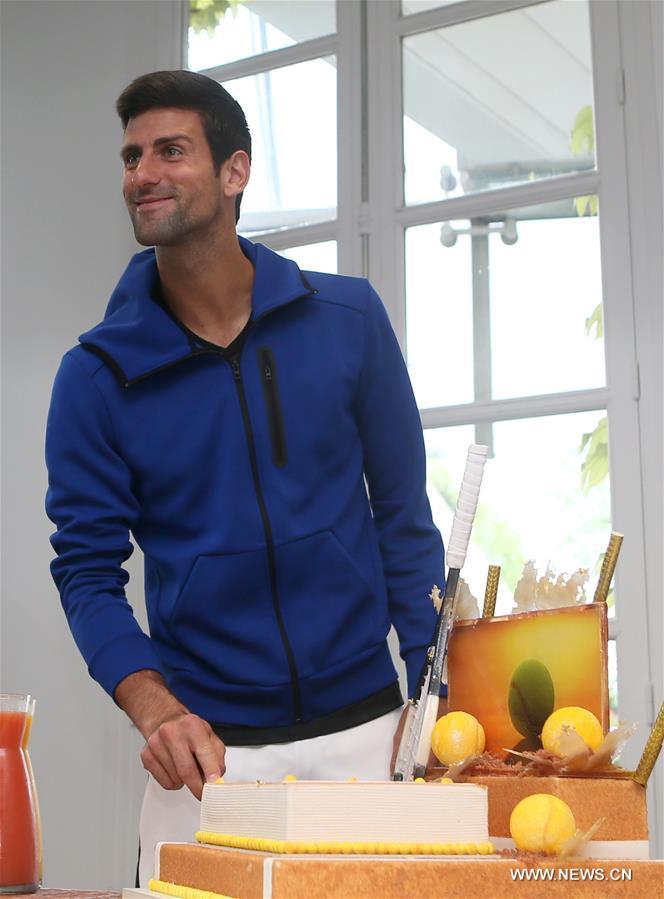 (Serbia's Novak Djokovic cuts his birthday cake at the Roland Garros 2016 French Open tennis tournament in Paris, France on May 22, 2016