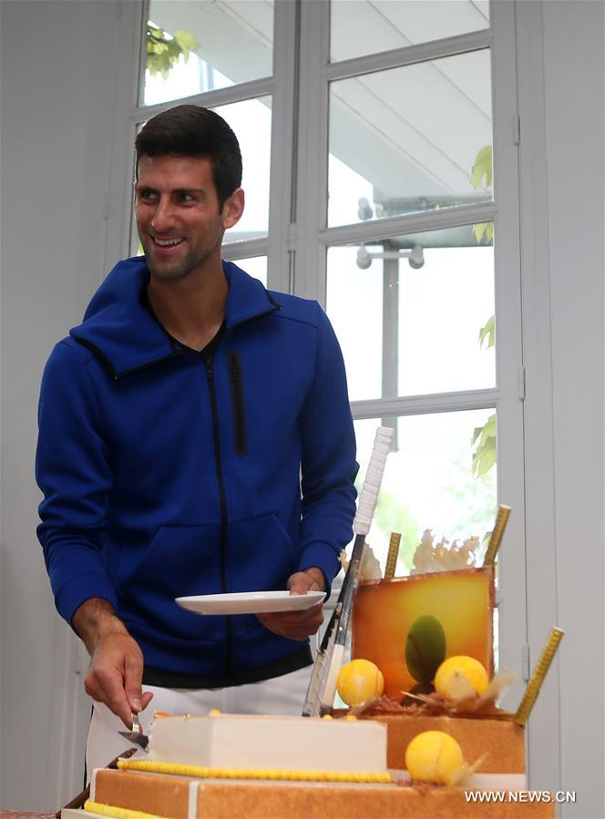 Serbia's Novak Djokovic cuts his birthday cake at the Roland Garros 2016 French Open tennis tournament in Paris, France on May 22, 2016