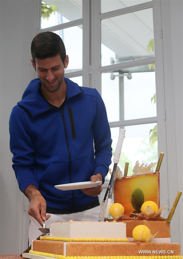 Serbia's Novak Djokovic cuts his birthday cake at the Roland Garros 2016 French Open tennis tournament in Paris, France on May 22, 2016