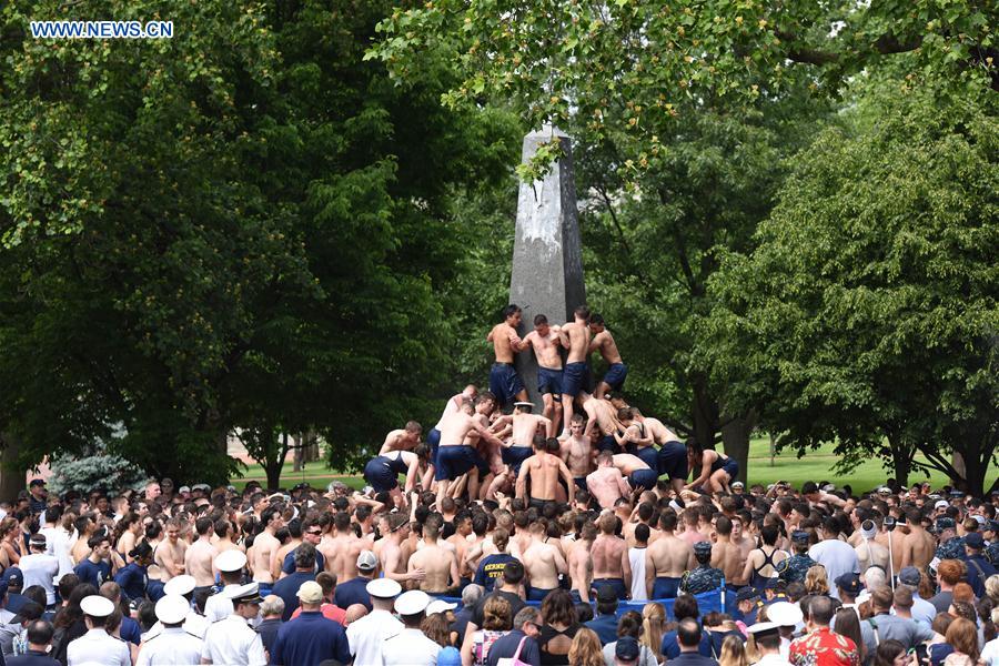 Plebes make a human wall to climb the Herndon Monument which is covered with vegetable shortening, at the U.S. Naval Academy (USNA) in Annapolis, Maryland, the United States, May 23, 2016.