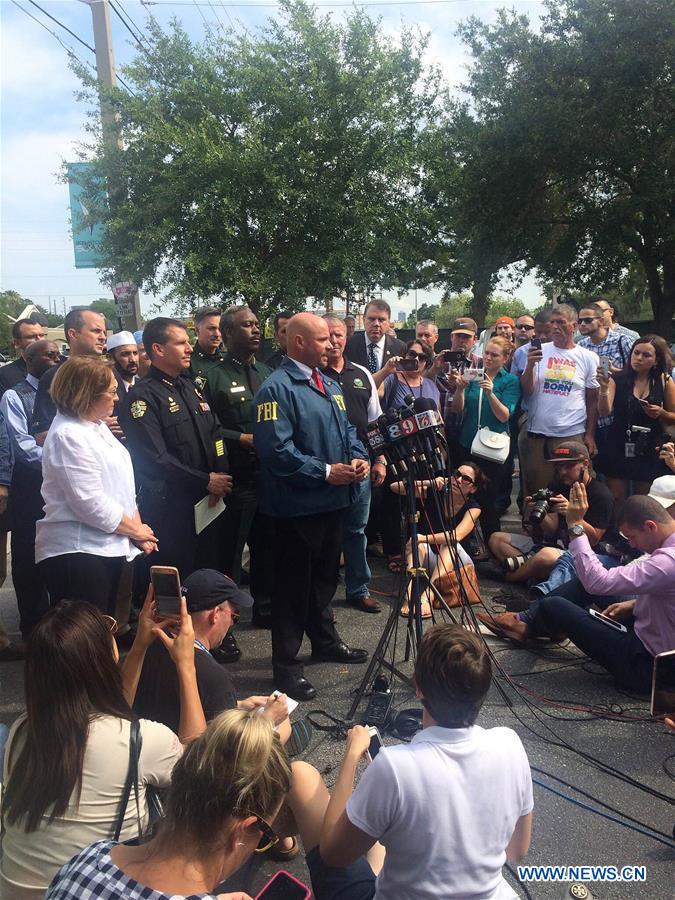 Highway-patrol troopers stand guard near the mass shooting scene in Orlando, the United States, June 12, 2016.